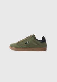 Low-top olive green suede sneaker with brown sole, round toe, lace-up closure, and black padded heel collar.