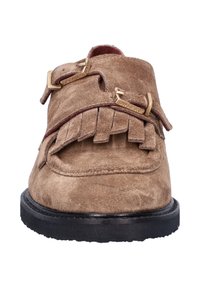 Tan suède jurk schoenen met franjes en dubbele goudkleurige gespen, met een zwarte rubberen zool en een gladde textuur.