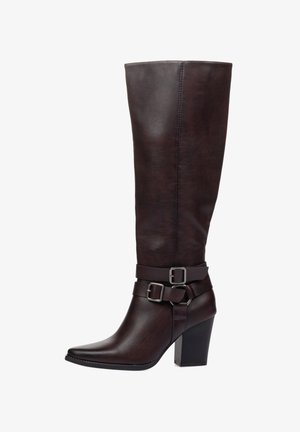 Bota alta de cuero marrón con punta estrecha, correa en el tobillo y hebillas plateadas. Cuenta con un tacón alto estructurado y textura suave.