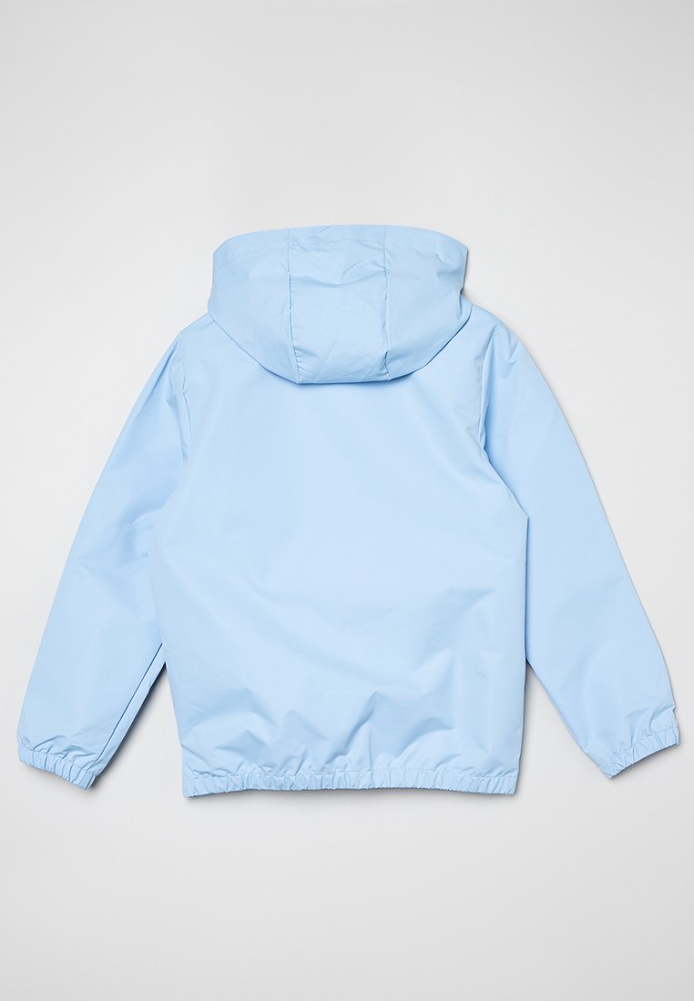 Chaqueta con capucha azul claro, con puños y cintura elásticos, visto desde atrás contra un fondo claro.