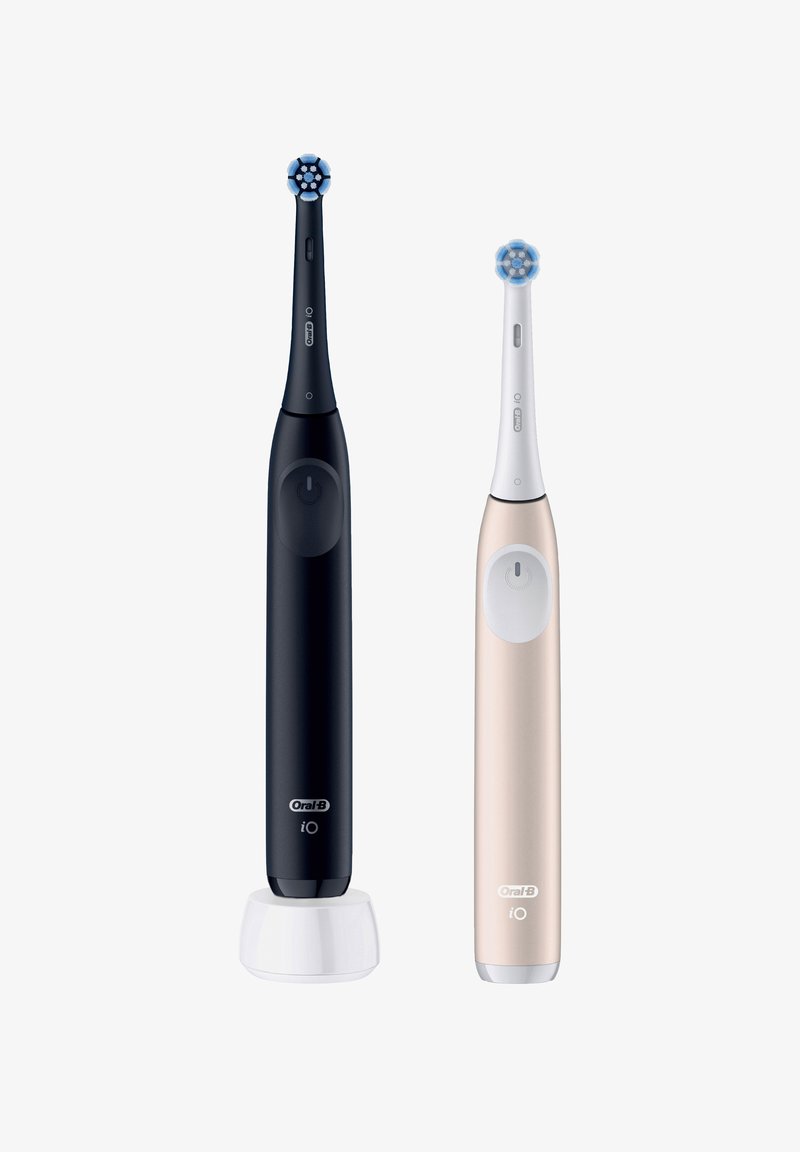 Deux brosses à dents électriques : l'une noire avec une tête de brosse circulaire et un accent blanc, et l'autre rose gold avec un design similaire, toutes deux élégantes.