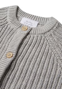 Cardigan grigio lavorato a maglia con una texture a coste, dotato di bottoni in legno e un'etichetta in tessuto cucita nel colletto.