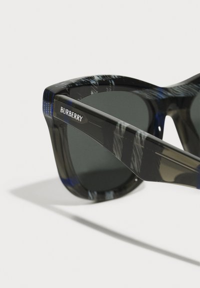 Burberry sunčane naočale u kvadratnom obliku, okvir od akrila sa crno-plavim uzorkom, tamne leće i srebrni logo na uhu.