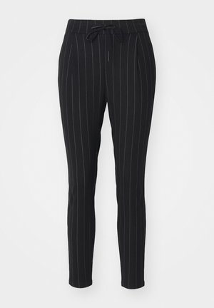 Schwarze Hose mit vertikalen weißen Streifen, aus einem weichen Material, mit einem Kordelzugbund und schmal zulaufendem Bein.