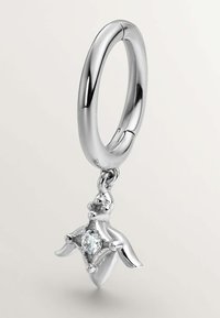 Arete de plata en forma de aro con un charm colgante que tiene la forma de una figura estilizada, con una gema clara en el centro y un acabado pulido.