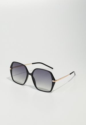 Schwarze Sonnenbrille mit sechseckiger Form, grauen verlaufenden Gläsern und goldenen Metallakzenten an den Bügeln. Mattes Finish auf dem Gestell.