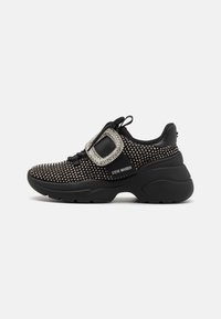 Sneaker sportivo nero con dettagli in strass, chiusura con lacci, tomaia in rete e suola spessa in gomma. Presenta un dettaglio decorativo con fibbia quadrata.
