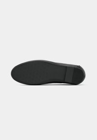 Black rubber shoe sole with textured grip pattern, curved shape, and reinforced heel. Flat profile suitable for casual footwear designs.