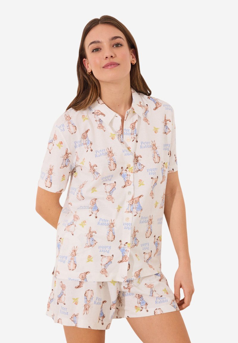 Witte short-sleeve pyjama set met illustraties van Peter Rabbit en blauwe tekst. Lichtgewicht katoen met een relaxte pasvorm en knoopsluiting.
