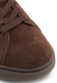 Baskets en daim marron avec bout arrondi, surface texturée et lacets assortis. Dotées d'une semelle en caoutchouc avec un motif discret pour l'adhérence.