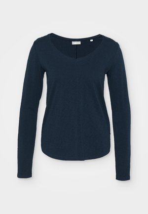 T-shirt à manches longues bleu marine avec un col en V, fabriqué à partir d'un tissu doux avec une surface légèrement texturée et un ourlet arrondi.