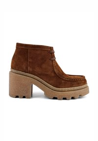 Braune Wildleder-Stiefeletten mit runder Zehenform, zwei dekorativen Schnürsenkeln und einer grob strukturierten Sohle mit hervorgehobenem Profil.