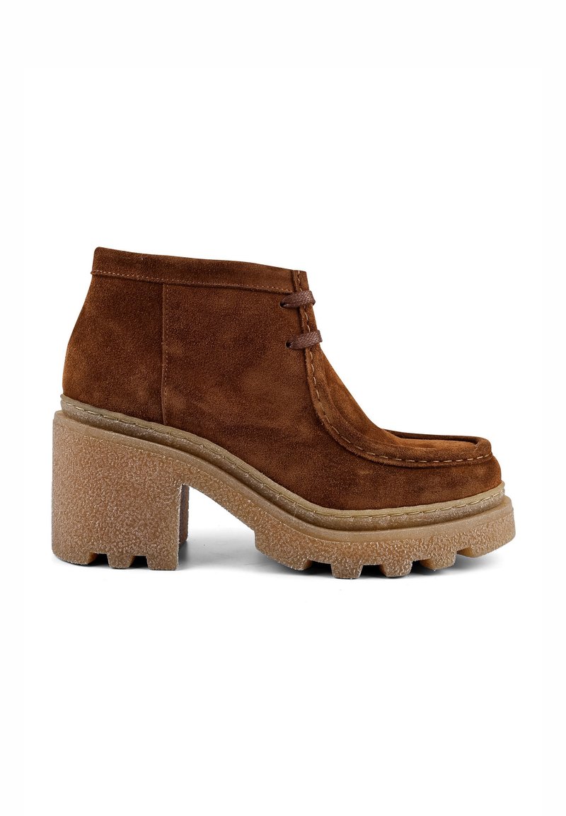 Braune Wildleder-Stiefeletten mit runder Zehenform, zwei dekorativen Schnürsenkeln und einer grob strukturierten Sohle mit hervorgehobenem Profil.