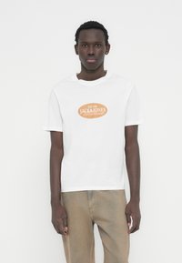 Λευκό βαμβακερό μπλουζάκι με πορτοκαλί οβάλ λογότυπο που γράφει «JACK&JONES Worldwide». Κοντά μανίκια, στρογγυλή λαιμόκοψη, κανονική εφαρμογή.