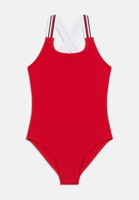 Κόκκινο ολόσωμο μαγιό με διασταυρωμένους λευκούς ιμάντες ώμου που διαθέτουν μαύρες και κόκκινες ρίγες, σε λευκό φόντο.