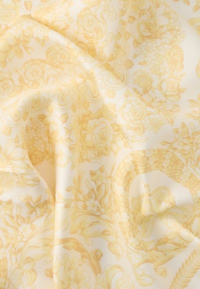 Κίτρινο ύφασμα με λουλουδάτο σχέδιο και μεταξένια υφή. Διαθέτει λεπτομερή μοτίβα από τριαντάφυλλα, φύλλα και περίτεχνα στρογγυλά διακοσμητικά σε κρεμ φόντο.