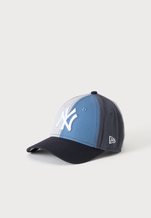 Casquette de baseball avec des panneaux blancs et bleu clair, une visière noire et un logo blanc des New York Yankees à l'avant.
