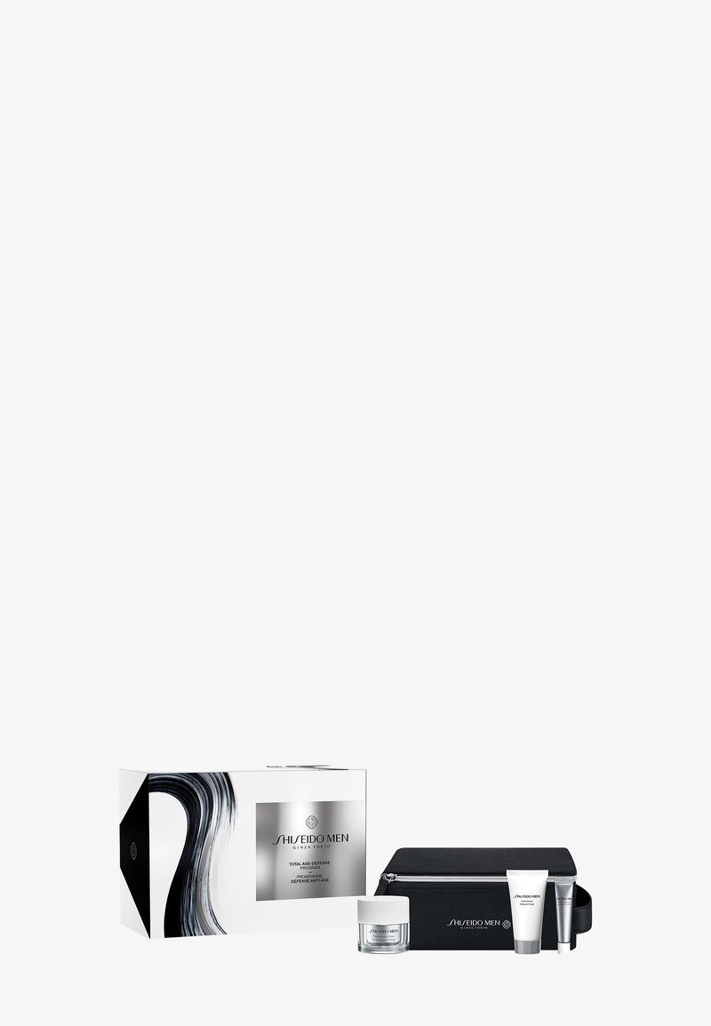 Zestaw kosmetyków Shiseido Men Total Age Defense, zawierający słoik kremu, dwie tubki oraz czarną saszetkę zapinaną na zamek, obok markowego pudełka.