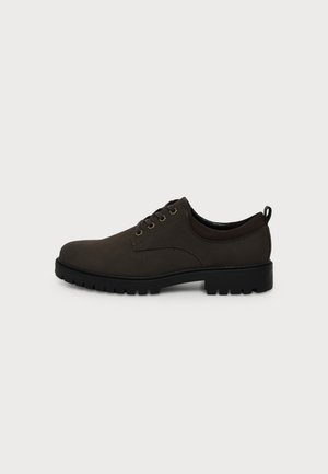 Chaussure habillée marron foncé à lacets avec semelle noire robuste et petit talon, vue de côté sur fond blanc uni.