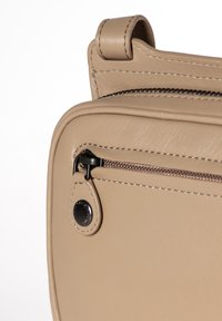 Borsa a spalla in pelle beige con chiusura a zip, dotata di un tirazip in metallo nero e cuciture visibili lungo i bordi.