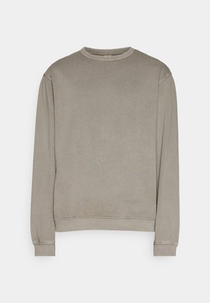 Sudadera beige lisa de manga larga con cuello redondo y puños y bajo acanalados sobre fondo blanco.