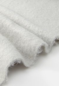 Hall värvitud materjaline siledast, tekstureeritud pinnast, millel on õrnalt volditud ja kergelt jahe välimus, esitades sujuvat ja minimalistlikku disaini.