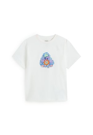 Hvid T-shirt med korte ærmer og et farverigt tegneserieudseende monster med grøn kasket og sneakers, placeret centralt på brystet.