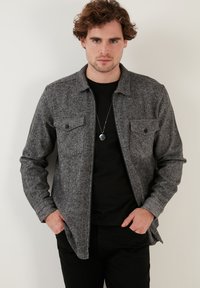 Grijze flanellen shirt met een rechte snit, twee borstzakken, knoopsluiting, lange mouwen en een lichte visgraatstructuur.