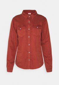 Camicia di jeans rossa con una leggera trama, maniche lunghe, due tasche sul petto, apertura con bottoni e colletto. Presenta bottoni argentati e orlo curvo.