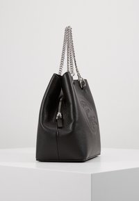 Sac à main en cuir noir avec finition texturée, forme structurée, double anses en chaîne argentée et compartiment zippé.