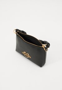 Black leather clutch bag with twisted handle, gold zipper, and a gold heart logo reading "LOVE MOSCHINO" on the front. Open zipper detail visible.