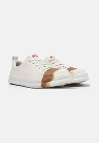Sneakers bianchi con tomaia in pelle liscia, punta tonda, dettaglio in vernice marrone sulla punta, e suola in gomma bianca spessa; design con lacci.