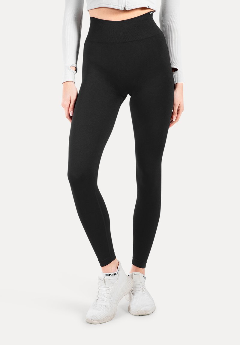 Hoge taille zwarte leggings van rekbare stof met een gladde textuur. Beschikt over een naadloze tailleband en een aansluitende silhoette voor comfort.