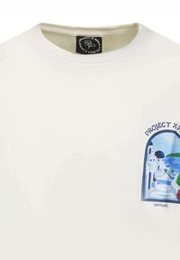 Camiseta de algodón blanca con un estampado gráfico en azul y verde de la arquitectura de Santorini. Cuello redondo con una textura suave.