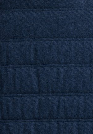 Navyblauwe gewatteerde stof met een zachte textuur, voorzien van horizontale gestikte naden die een patroon van verhoogde en vlakke secties creëren.