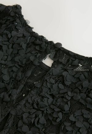 Melnas mežģīnes audums ar teksturētiem ziedu aplikācijas, piedāvā noapaļotu kakla izgriezumu un pogu aizdari aizmugurē. Detalizēts un sarežģīts dizains.