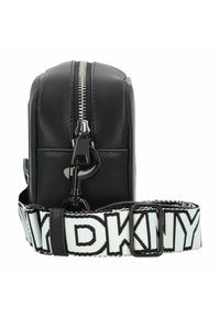 Borsa a tracolla nera in pelle con finitura strutturata, chiusura con zip e una tracolla bianca a contrasto con il logo "DKNY". Dettagli in metallo.
