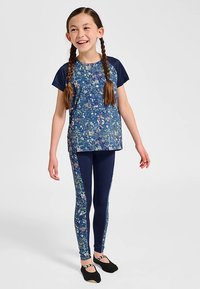 Marineblå blommigt träningsset med kortärmad topp med mönstrad framsida och matchande leggings med blomdetaljer på sidan.