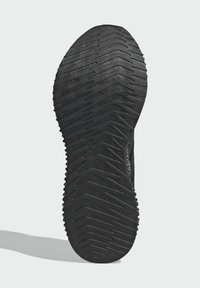 Black athletic shoe sole with a textured rubber surface, featuring a zigzag tread pattern for traction and stability.