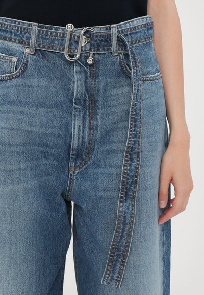 Lichte blauwe denimjeans met een hoge taille, een zilverkleurige gesp en een lange stoffen riem met contrasterende stiksels langs de zijkanten.