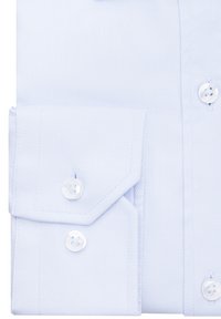 Jasnoniebieska koszula z diagonalną teksturą, z podwójnymi guzikami przy mankietach i białymi guzikami. Starannie złożona, ukazująca kołnierzyk i mankiety koszuli.