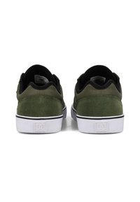 Green suede skate shoes feature a white rubber sole with a black stripe and logo detail at the heel, designed for comfort and durability.