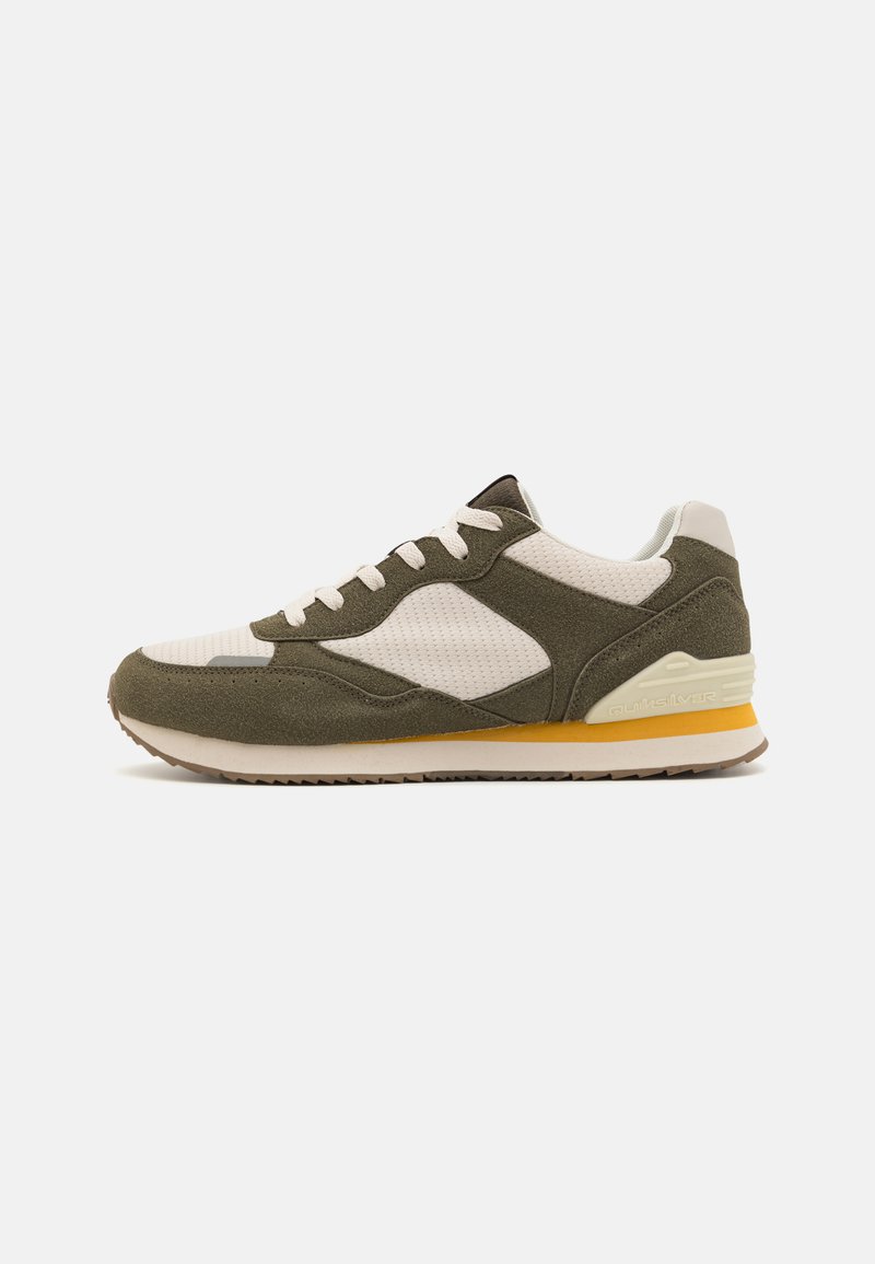 Olive green and cream sneakers with a mesh upper, suede accents, white laces, and a rubber sole featuring a yellow detail on the heel.