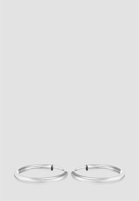 Pendientes de aro de plata con una superficie lisa y pulida y un diseño ligero. Presentan una forma circular continua y un estilo minimalista.