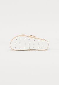 Beige platformová sandál s pletenou jute střední podrážkou, bílou gumovou spodní částí a dvěma nastavitelnými kovovými sponami v horní části.