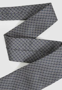 Marinblå siden slips med ett geometriskt diamantmönster i krämfärg, med en mjuk textur och avsmalnande ändar.