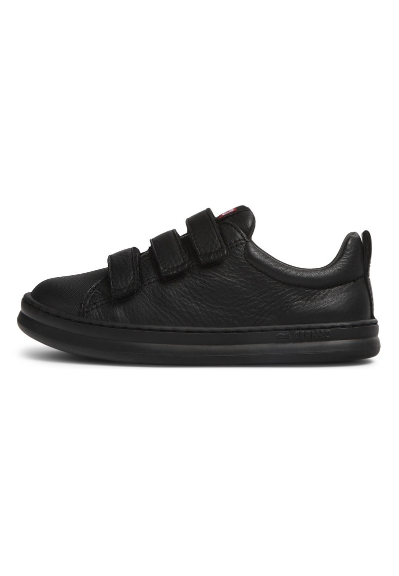 Chaussures en cuir noir avec un bout arrondi, trois bandes Velcro réglables et une finition texturée. La semelle est rembourrée et plate.