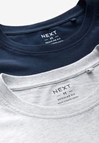 Zwei mittelgroße T-Shirts mit regulärer Passform und Rundhalsausschnitt, eins in Navyblau und eins in Hellgrau, die Innenhals-Etiketten mit Marken- und Herkunftsinformationen zeigen.