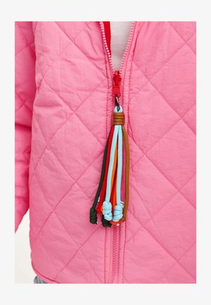 Prešívaná ružová bunda s červeným zipsom a viacfarebnou šnúrkou na zips. Materiál vyzerá ľahko a štruktúrovane.