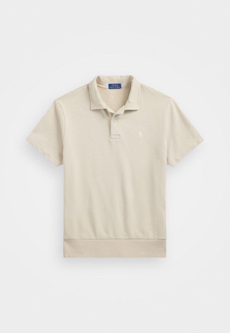 Beige rövid ujjú póló, pamutból készült, gallérral, két gombbal és egy kis hímzett logóval a mellen. Simább tapintású.